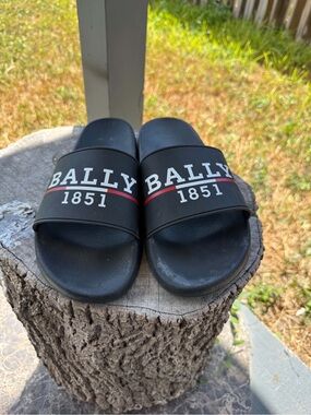 Bally black slides with white text reading 'BALLY 1851' with a red line undernea